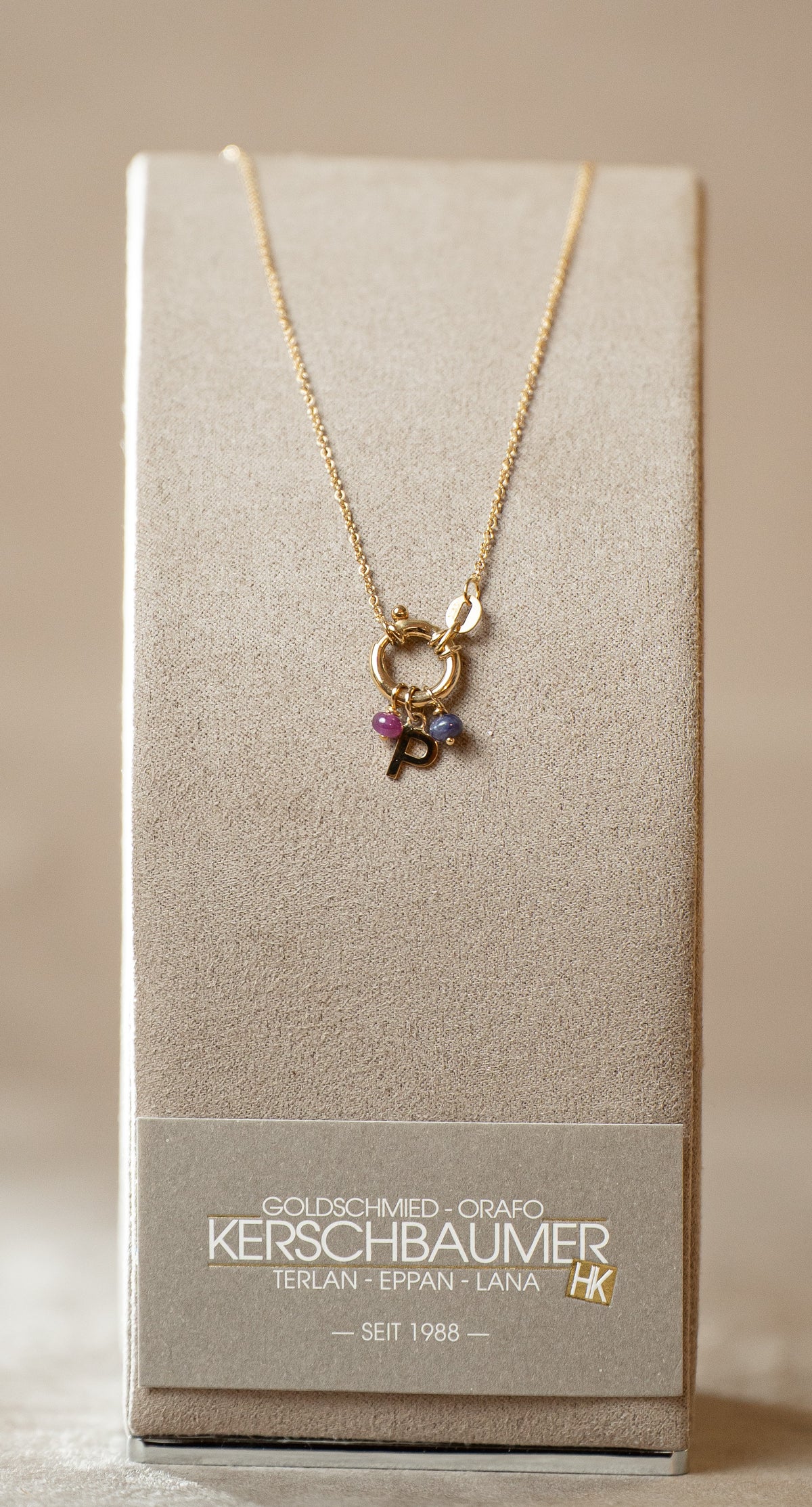 Collana rolo con chiusura a molla, pietre naturali e lettera – oro giallo 750